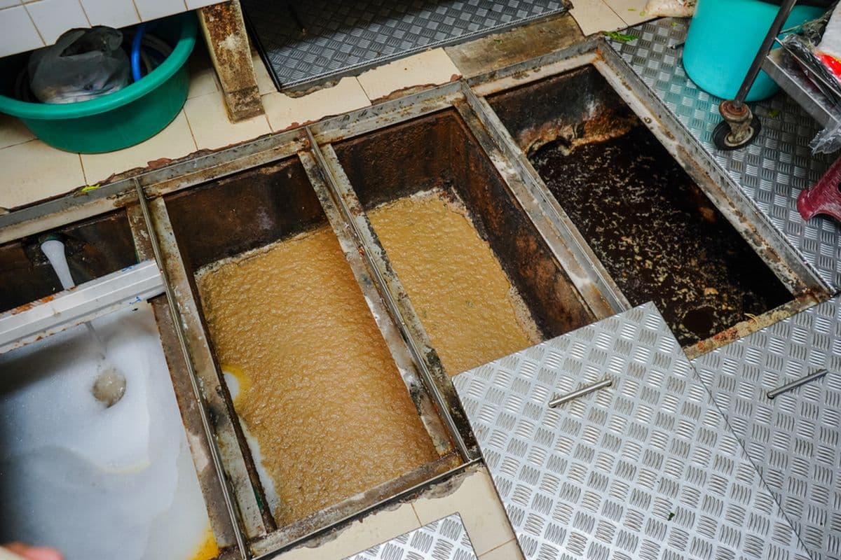 Open grease trap interceptor showing separated surface layer.